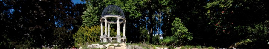 Ein blühender Garten mit bunten Blumen, einem kleinen Teich und einem Pavillon im Hintergrund, umgeben von Bäumen., © Staatsministerium Baden-Württemberg