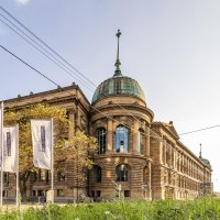 The Haus der Wirtschaft in Stuttgart with its magnificent façade and dome, surrounded by flags and green vegetation., © © Stuttgart-Marketing GmbH, Werner Dieterich The Haus der Wirtschaft in Stuttgart with its magnificent façade and dome, surrounded by flags and green vegetation., © © Stuttgart-Marketing GmbH, Werner Dieterich