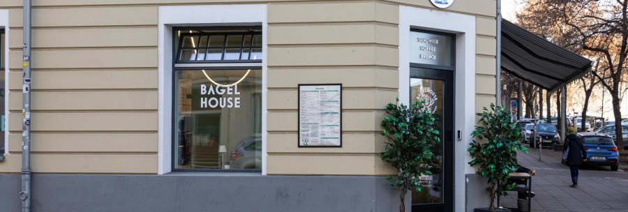 A caf&eacute; called Bagel House with a large shop window and an entrance door. There are plants in front of the building and a menu is visible., &copy; Stuttgart-Marketing GmbH, Sarah Schmid