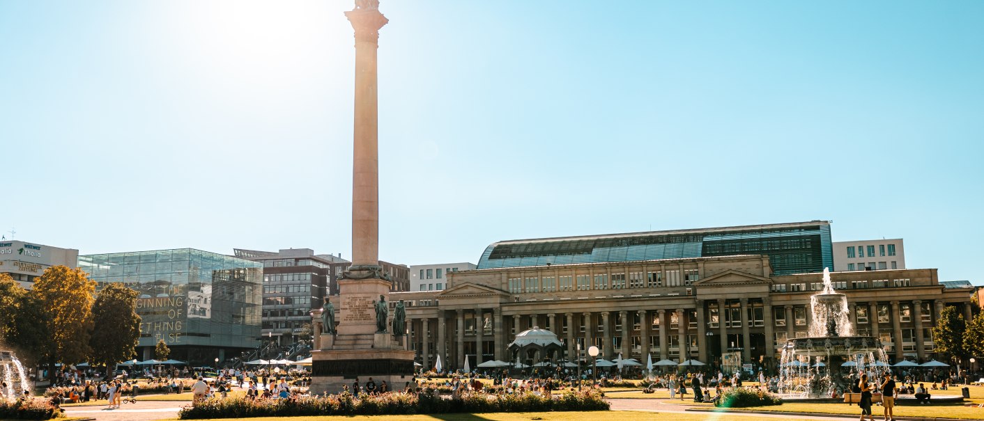 Der Schlossplatz in Stuttgart bei Sonnenschein, mit der Jubiläumssäule und dem Königsbau im Hintergrund. Menschen genießen den sonnigen Tag., © SMG Stuttgart Marketing GmbH - Sarah Schmid Der Schlossplatz in Stuttgart bei Sonnenschein, mit der Jubiläumssäule und dem Königsbau im Hintergrund. Menschen genießen den sonnigen Tag., © SMG Stuttgart Marketing GmbH - Sarah Schmid
