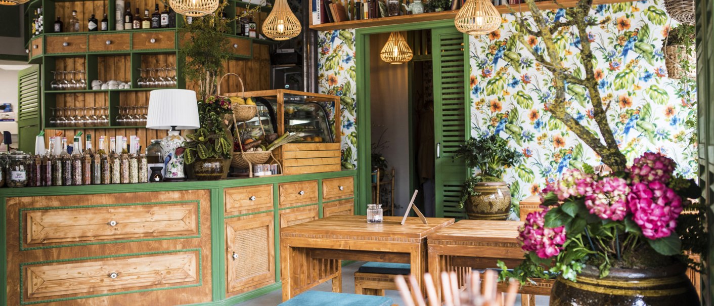 Cozy guest room with wooden furniture, colorful flowers, shelves full of bottles and books. Bright lamps and floral wallpaper create an inviting atmosphere., &copy; Vietal Kitchen