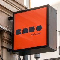 A bright orange sign reading 'Kado die Eckbar' hangs on the wall of a building in Leonhardstra&szlig;e., &copy; Stuttgart-Marketing GmbH, Sarah Schmid
