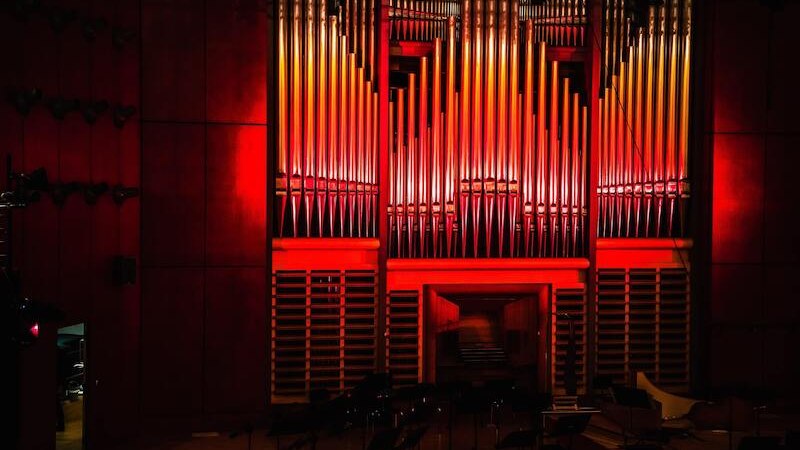 An impressive organ in a concert hall, dramatically illuminated with red light. The pipes stretch up to the ceiling., © Staatliche Hochschule für Musik und Darstellende Kunst An impressive organ in a concert hall, dramatically illuminated with red light. The pipes stretch up to the ceiling., © Staatliche Hochschule für Musik und Darstellende Kunst
