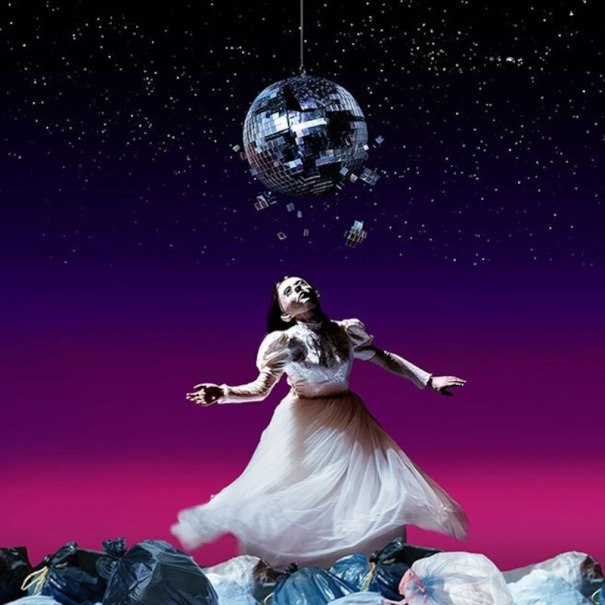 Eine Frau in einem wei&szlig;en Kleid tanzt unter einer zerbrochenen Discokugel vor einem sternenklaren Himmel, umgeben von M&uuml;lls&auml;cken., &copy; Theaterhaus Stuttgart e.V.