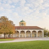 Historic building with dome and arches, surrounded by autumnal trees and manicured lawns., © Simon Sommer Historic building with dome and arches, surrounded by autumnal trees and manicured lawns., © Simon Sommer