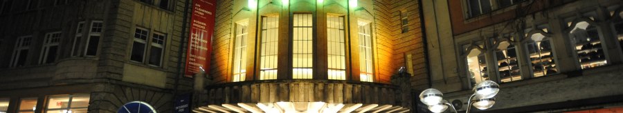Das Alte Schauspielhaus bei Nacht, beleuchtet mit bunten Lichtern. Der Eingang ist von historischen Gebäuden umgeben., © Schauspielbühnen Stuttgart