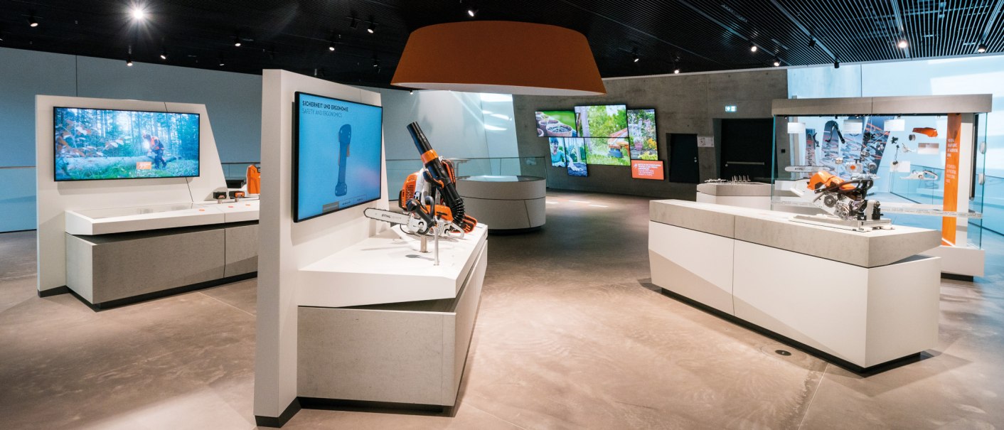 A modern exhibition featuring STIHL products and displays. A showcase of innovations and technologies in a bright, open space., © STIHL Markenwelt A modern exhibition featuring STIHL products and displays. A showcase of innovations and technologies in a bright, open space., © STIHL Markenwelt