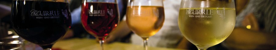 Vier Weingläser mit unterschiedlichen Weinsorten stehen auf einem Tisch. Im Hintergrund sind unscharf Personen zu erkennen., © Stuttgart-Marketing GmbH
