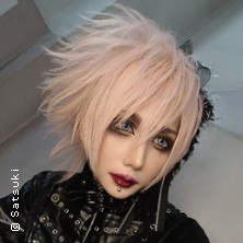 Eine Person mit blonden, zerzausten Haaren und auffälligem Make-up trägt schwarze, stilvolle Kleidung., © links im Bild Eine Person mit blonden, zerzausten Haaren und auffälligem Make-up trägt schwarze, stilvolle Kleidung., © links im Bild