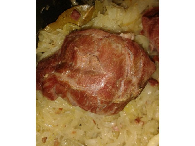 Ein Stück Fleisch liegt auf einem Bett aus Sauerkraut. Das Gericht scheint in einem Topf oder einer Pfanne zubereitet zu werden., © Kultweine-Kochwelten-Kunstücke - Kochschule Sonja Lenz Ein Stück Fleisch liegt auf einem Bett aus Sauerkraut. Das Gericht scheint in einem Topf oder einer Pfanne zubereitet zu werden., © Kultweine-Kochwelten-Kunstücke - Kochschule Sonja Lenz