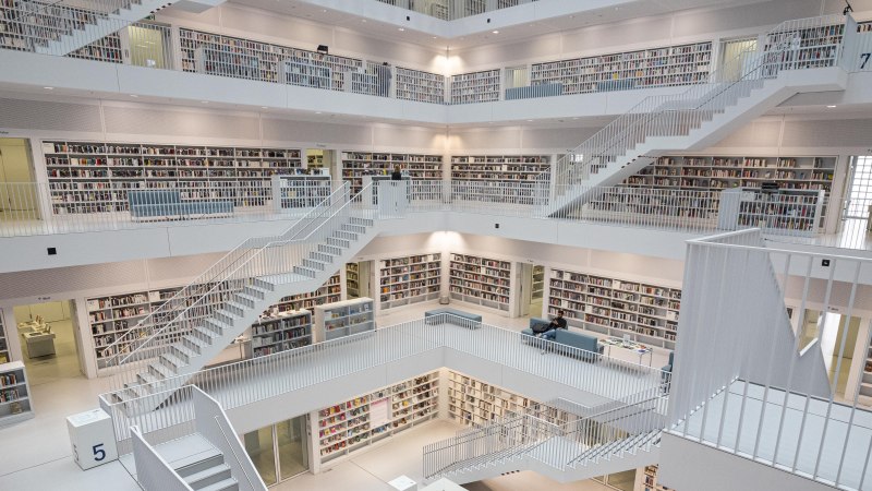 Moderne Bibliothek mit mehreren Etagen, weißen Wänden und zahlreichen Bücherregalen. Offenes Design mit Treppen und Sitzbereichen., © SMG, Sarah Schmid Moderne Bibliothek mit mehreren Etagen, weißen Wänden und zahlreichen Bücherregalen. Offenes Design mit Treppen und Sitzbereichen., © SMG, Sarah Schmid