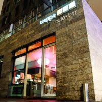 Modernes Café mit Glasfront, beleuchtetem Innenraum und Schriftzug "treppe café • bar" an der Fassade., © Café Treppe