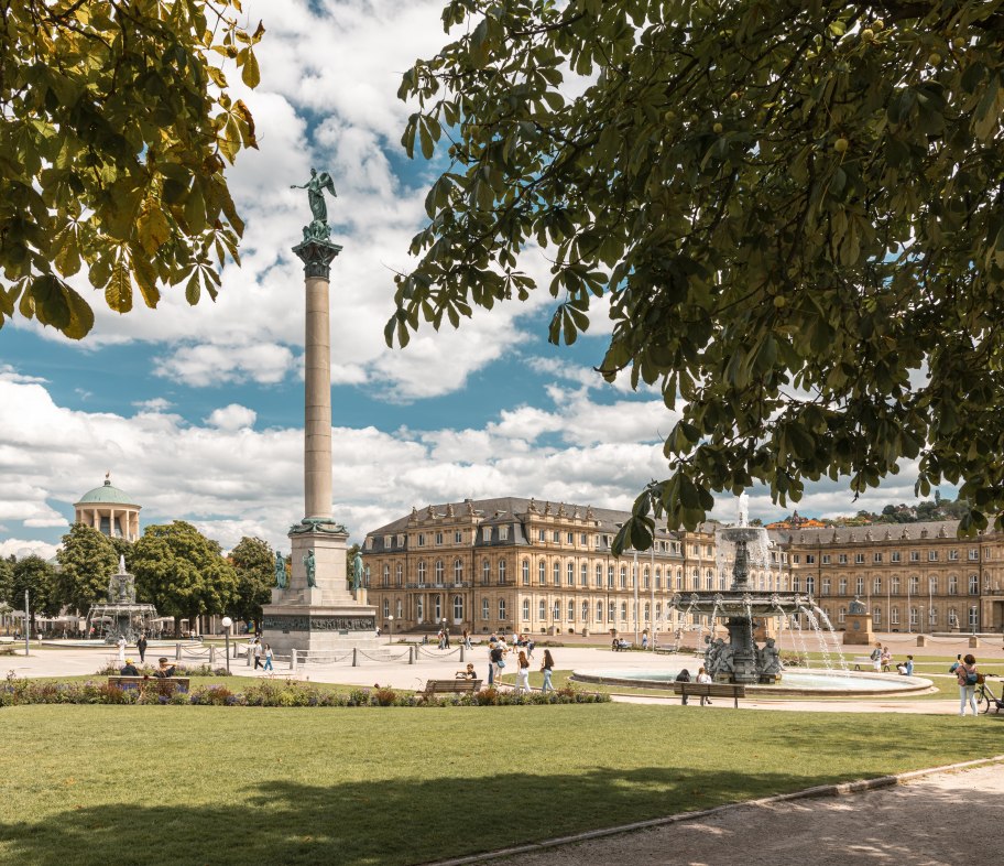 Der Schlossplatz in Stuttgart mit der Jubiläumssäule und dem Neuen Schloss im Hintergrund. Menschen spazieren und entspannen im sonnigen Park., © SMG, Sarah Schmid Der Schlossplatz in Stuttgart mit der Jubiläumssäule und dem Neuen Schloss im Hintergrund. Menschen spazieren und entspannen im sonnigen Park., © SMG, Sarah Schmid