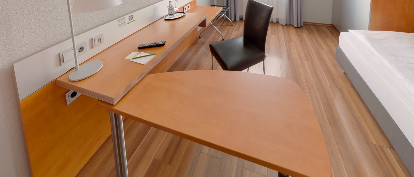 Modernes Einzelzimmer mit Holzfußboden, Schreibtisch, Stuhl, Flachbildfernseher und Bett. Helle Vorhänge und minimalistisches Design., © attimo Hotel Stuttgart Modernes Einzelzimmer mit Holzfußboden, Schreibtisch, Stuhl, Flachbildfernseher und Bett. Helle Vorhänge und minimalistisches Design., © attimo Hotel Stuttgart