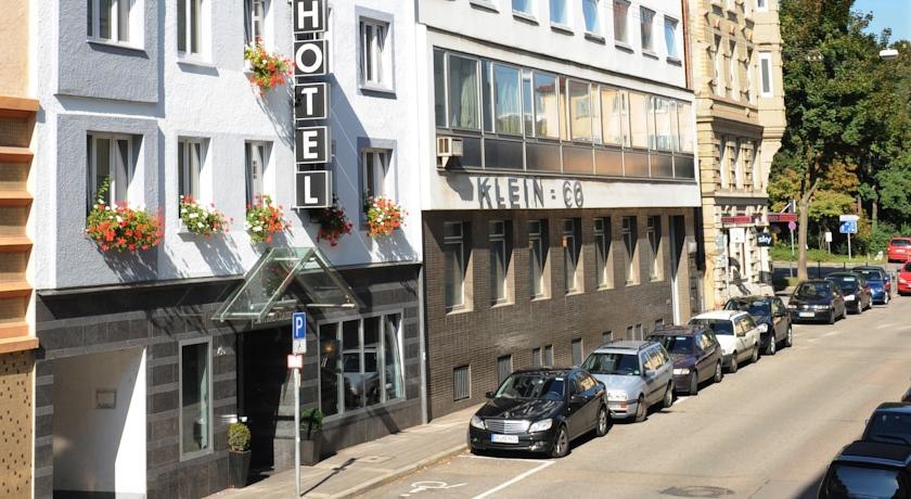 Street view with a hotel building, flowers on the windows and parked cars along the street., © TOMAS