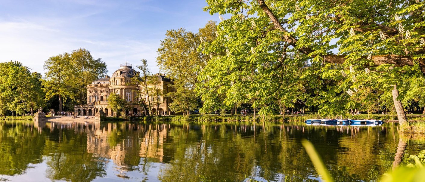 Monrepos Castle is reflected in the calm lake, surrounded by lush greenery and bright sunshine. An idyllic scene of nature and architecture., © © Stuttgart-Marketing GmbH, Werner Dieterich Monrepos Castle is reflected in the calm lake, surrounded by lush greenery and bright sunshine. An idyllic scene of nature and architecture., © © Stuttgart-Marketing GmbH, Werner Dieterich