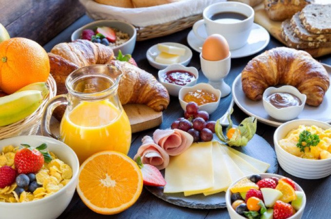 Ein reich gedeckter Frühstückstisch mit Croissants, Obst, Käse, Schinken, Eiern, Müsli und Orangensaft., © Cool-Tours StattReisen Ein reich gedeckter Frühstückstisch mit Croissants, Obst, Käse, Schinken, Eiern, Müsli und Orangensaft., © Cool-Tours StattReisen