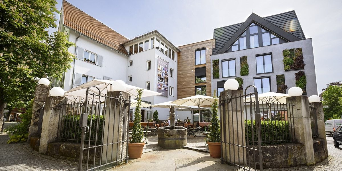 Hotel-Restaurant Schwanen with modern fa&ccedil;ade, terrace with parasols and decorative plants. Historic gate in the foreground., &copy; Hotel-Restaurant Schwanen