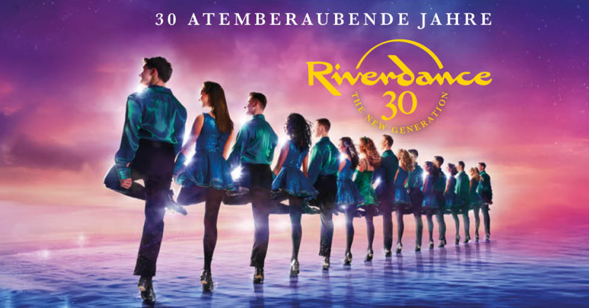 Tänzer in blauen Kostümen stehen in einer Reihe auf einer Bühne. Der Hintergrund ist in lila und rosa Tönen gehalten. Oben steht '30 Atemberaubende Jahre'., © links im Bild Tänzer in blauen Kostümen stehen in einer Reihe auf einer Bühne. Der Hintergrund ist in lila und rosa Tönen gehalten. Oben steht '30 Atemberaubende Jahre'., © links im Bild