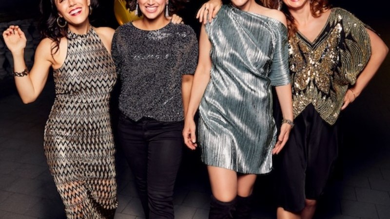 Vier Frauen in eleganter Abendgarderobe posieren lächelnd mit goldenen Luftballons im Hintergrund., © Renitenztheater Stuttgart e.V. Vier Frauen in eleganter Abendgarderobe posieren lächelnd mit goldenen Luftballons im Hintergrund., © Renitenztheater Stuttgart e.V.