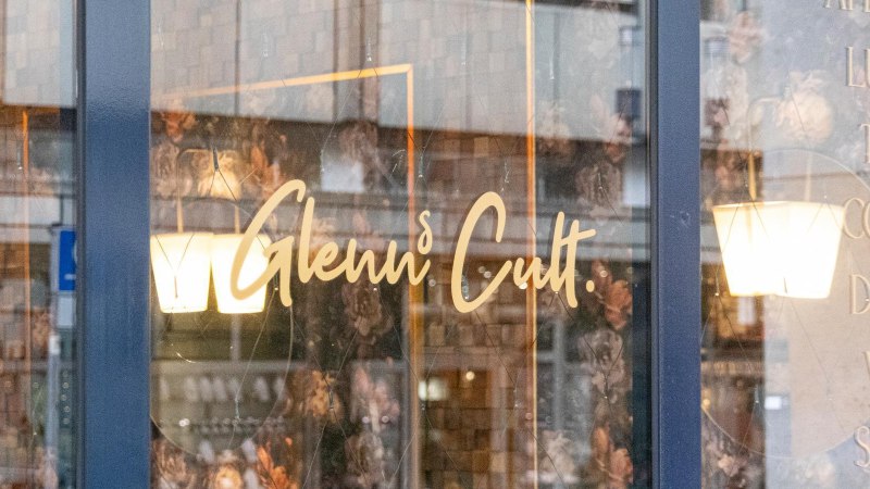 Fensterscheibe eines Caf&eacute;s mit dem Schriftzug 'Glenn's Cult' und Angeboten wie Aperitivo, Lunch, Tapas, Coffee, Drinks, Vino, Spirits., &copy; SMG, Sarah Schmid