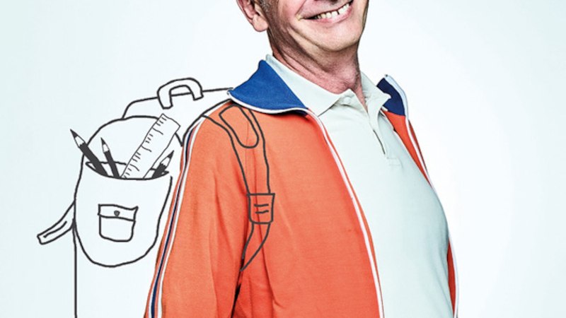 Ein Mann in einer orange-blauen Jacke hält ein Mikrofon mit Windschutz und Papier. Er schaut zur Seite vor einem neutralen Hintergrund., © Theaterhaus Stuttgart e.V. Ein Mann in einer orange-blauen Jacke hält ein Mikrofon mit Windschutz und Papier. Er schaut zur Seite vor einem neutralen Hintergrund., © Theaterhaus Stuttgart e.V.
