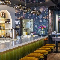 Eleganter Gastraum mit Marmortheke, gelben Hockern und stilvoller Beleuchtung. Die Bar ist gut best&uuml;ckt, mit Gl&auml;sern und Flaschen dekoriert., &copy; SMG, Sarah Schmid