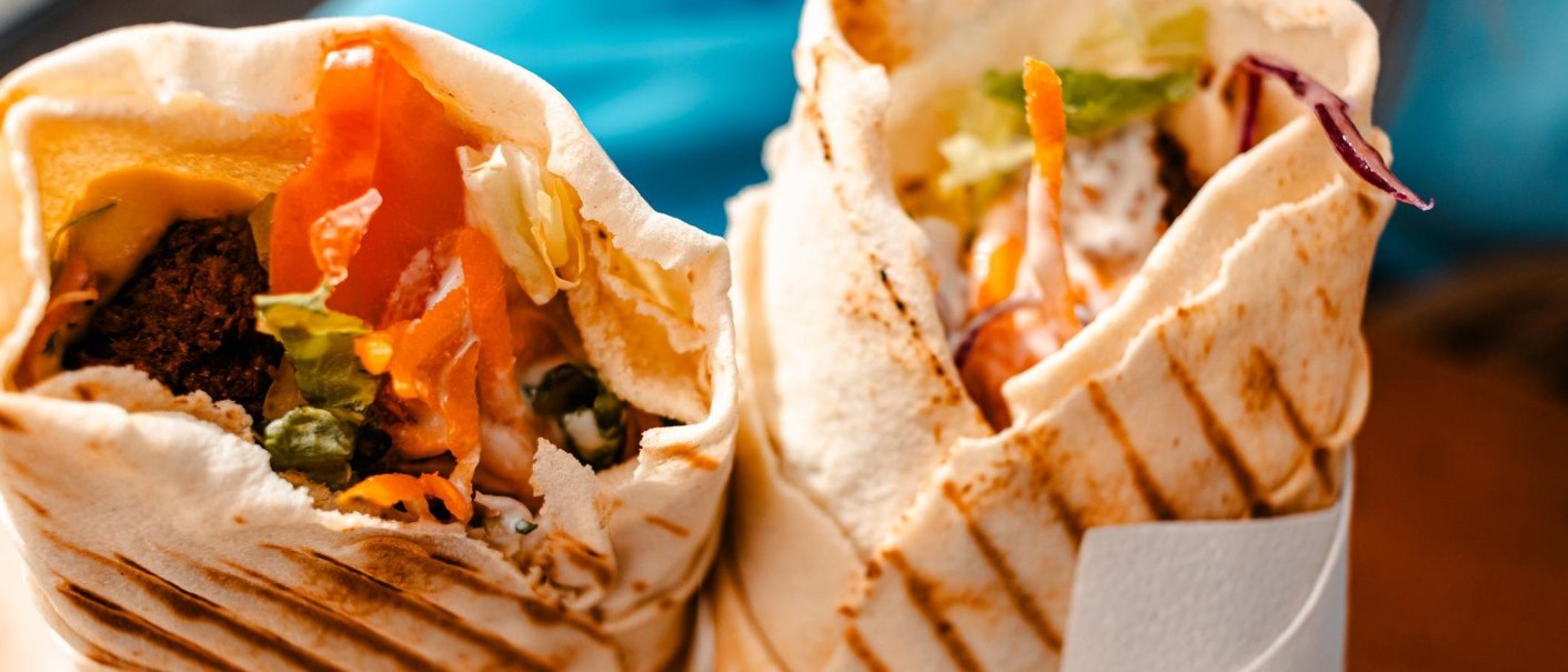 Two filled wraps with vegetables and falafel, appetizingly arranged. Close-up shows fresh ingredients and grilled bread., © Stuttgart Marketing GmbH, Sarah Schmid Two filled wraps with vegetables and falafel, appetizingly arranged. Close-up shows fresh ingredients and grilled bread., © Stuttgart Marketing GmbH, Sarah Schmid