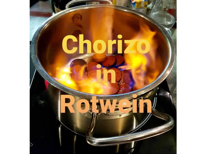 A pot of chorizo in red wine burns on a stove. Text: "Chorizo in red wine"., &copy; Kultweine-Kochwelten-Kunst&uuml;cke - Kochschule Sonja Lenz