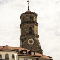 Turm der Stiftskirche Stuttgart mit Uhr und Wetterhahn, umgeben von Gebäuden unter bewölktem Himmel., © Stuttgart Marketing GmbH, Sarah Schmid Turm der Stiftskirche Stuttgart mit Uhr und Wetterhahn, umgeben von Gebäuden unter bewölktem Himmel., © Stuttgart Marketing GmbH, Sarah Schmid