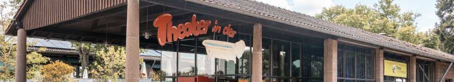 Entrance of the theater in the bathtub with glass front and red car in front of it. A sign with the name of the theater and a bathtub is visible., &copy; SMG Stuttgart Marketing GmbH - Sarah Schmid