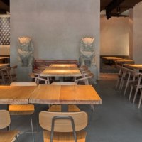 Modern restaurant with wooden tables, chairs and Asian decorations. Subtle lighting and artistic wall design create an inviting atmosphere., © Breitengrad17, Stuttgart