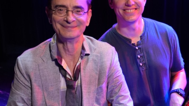Zwei Männer lächeln in die Kamera, einer trägt ein Sakko, der andere ein T-Shirt. Sie stehen vor einem dunklen Hintergrund., © Renitenztheater Stuttgart e.V. Zwei Männer lächeln in die Kamera, einer trägt ein Sakko, der andere ein T-Shirt. Sie stehen vor einem dunklen Hintergrund., © Renitenztheater Stuttgart e.V.