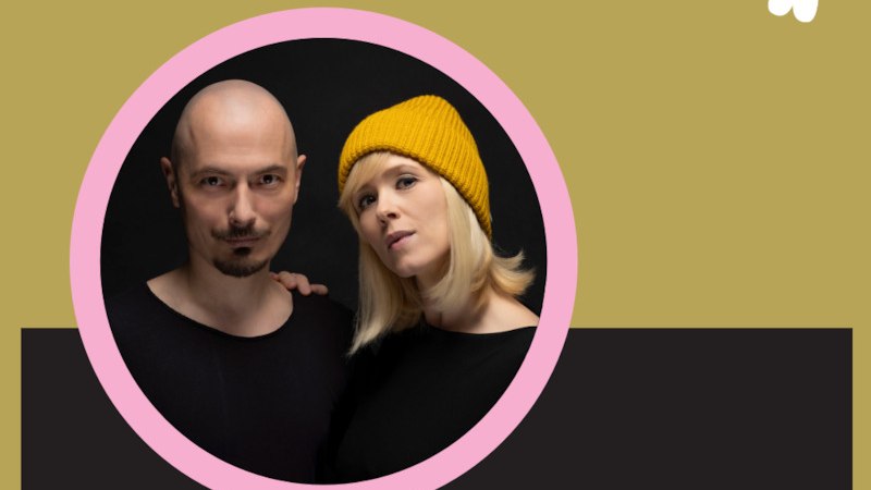 Ein Mann mit Glatze und eine Frau mit gelber M&uuml;tze posieren vor einem dunklen Hintergrund. Beide tragen schwarze Kleidung., &copy; Renitenztheater Stuttgart e.V.