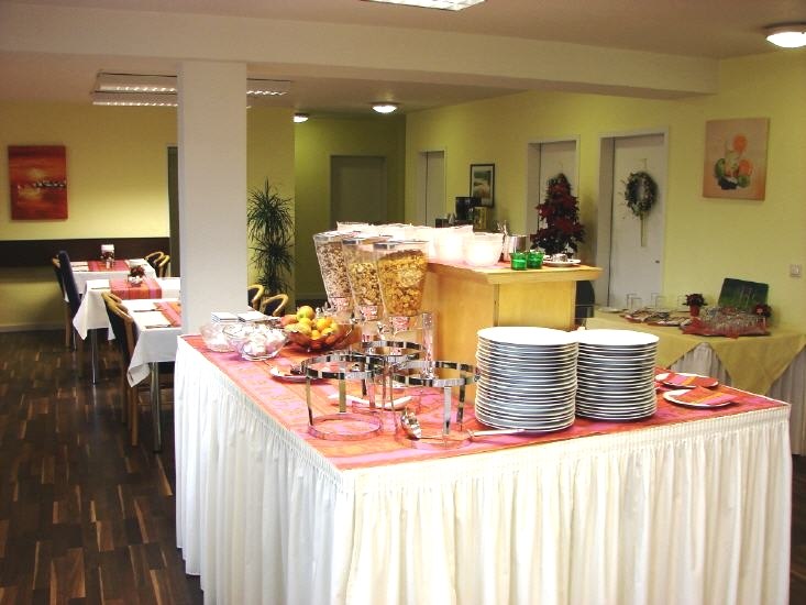 Ein Fr&uuml;hst&uuml;cksraum mit Buffet, Geschirr, M&uuml;sli und Obst. Tische sind gedeckt, der Raum ist hell und einladend., &copy; Central Hotel