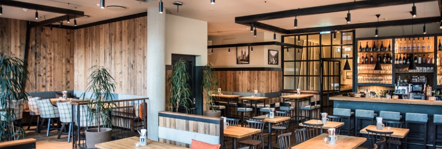 Modern brewery with wooden furniture, bar and plants. Cozy atmosphere with wooden walls and stylish lighting., © Andreas Engelhard - Engelhard Photography