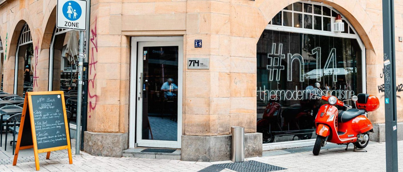 Eingang eines Restaurants mit '#n14' auf dem Fenster. Ein roter Motorroller steht davor. Ein Schild mit Tagesmenü ist aufgestellt., © Stuttgart Marketing GmbH, Sarah Schmid