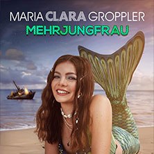 Eine Frau mit Meerjungfrauenflosse lächelt am Strand. Im Hintergrund ist ein brennendes Schiff zu sehen. Titel: Maria Clara Groppler - Mehrjungfrau., © links im Bild Eine Frau mit Meerjungfrauenflosse lächelt am Strand. Im Hintergrund ist ein brennendes Schiff zu sehen. Titel: Maria Clara Groppler - Mehrjungfrau., © links im Bild