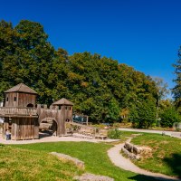 Spielplatz mit Holzkonstruktionen im Stadtpark Welzheim, umgeben von grünen Bäumen und blauem Himmel., © Stuttgart-Marketing GmbH, Thomas Niedermüller