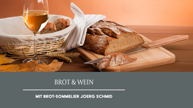 Ein Glas Weißwein steht neben einem Korb mit Brot und einem Laib Brot auf einem Schneidebrett. Herbstblätter dekorieren die Szene., © Weinmanufaktur Stuttgart eG Ein Glas Weißwein steht neben einem Korb mit Brot und einem Laib Brot auf einem Schneidebrett. Herbstblätter dekorieren die Szene., © Weinmanufaktur Stuttgart eG