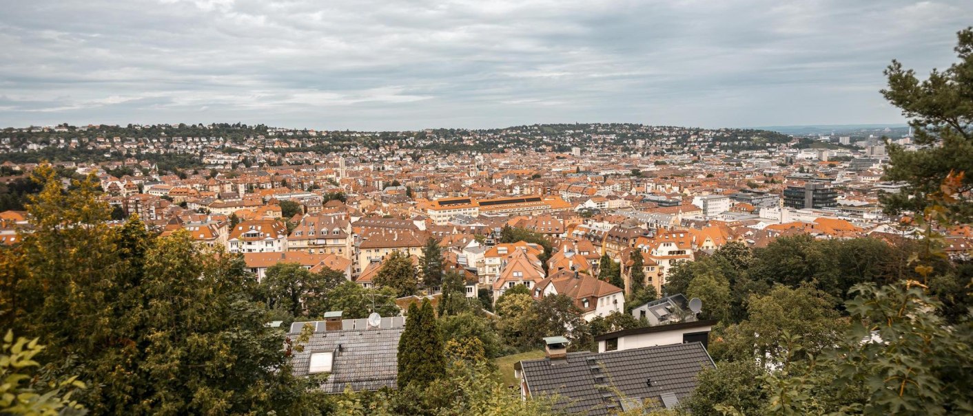 Panoramablick auf Stuttgart von der Hasenbergsteige aus. Die Stadt erstreckt sich mit roten Dächern und grünen Hügeln im Hintergrund., © Stuttgart-Marketing GmbH, Sarah Schmid Panoramablick auf Stuttgart von der Hasenbergsteige aus. Die Stadt erstreckt sich mit roten Dächern und grünen Hügeln im Hintergrund., © Stuttgart-Marketing GmbH, Sarah Schmid