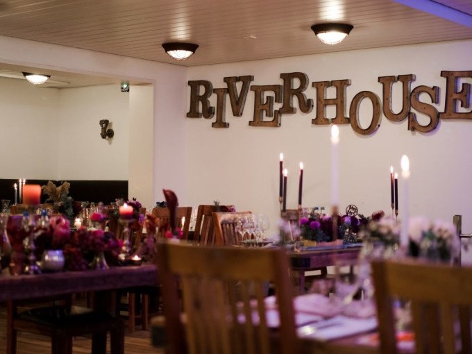 Festively decorated room with candles and decorations, 'RIVERHOUSE' lettering on the wall., © Cool-Tours StattReisen Festively decorated room with candles and decorations, 'RIVERHOUSE' lettering on the wall., © Cool-Tours StattReisen