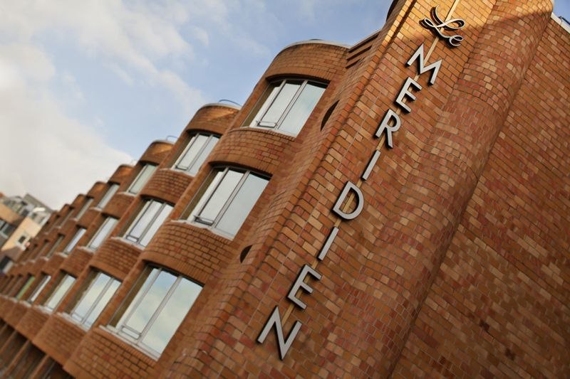 Backsteinfassade des Le Méridien Stuttgart mit großen Fenstern und Schriftzug. Der Himmel ist leicht bewölkt., © Hotel Le Méridien Backsteinfassade des Le Méridien Stuttgart mit großen Fenstern und Schriftzug. Der Himmel ist leicht bewölkt., © Hotel Le Méridien