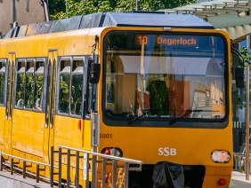 Gelbe Zahnradbahn der Linie 10 in Stuttgart am Marienplatz. Die Bahn fährt Richtung Degerloch. Im Hintergrund sind Schienen und Gebäude zu sehen., © Stuttgart-Marketing GmbH, Thomas Niedermüller