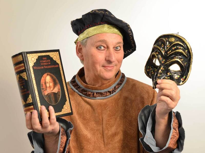 A person in historical dress holds a book by Shakespeare and a decorative mask in his hands., &copy; Theaterhaus Stuttgart e.V.