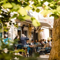 Menschen sitzen im Außenbereich eines Cafés namens La Concha, umgeben von Graffiti und Bäumen. Die Szene wirkt lebendig und entspannt., © SMG Stuttgart Marketing GmbH - Sarah Schmid Menschen sitzen im Außenbereich eines Cafés namens La Concha, umgeben von Graffiti und Bäumen. Die Szene wirkt lebendig und entspannt., © SMG Stuttgart Marketing GmbH - Sarah Schmid