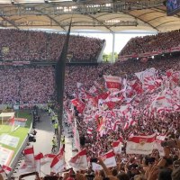 Blick in die Cannstatter Kurve der Mercedes-Benz Arena Stuttgart. Fans schwenken rot-wei&szlig;e Fahnen und halten Banner hoch. Die Trib&uuml;nen sind voll besetzt., &copy; Stuttgart-Marketing GmbH