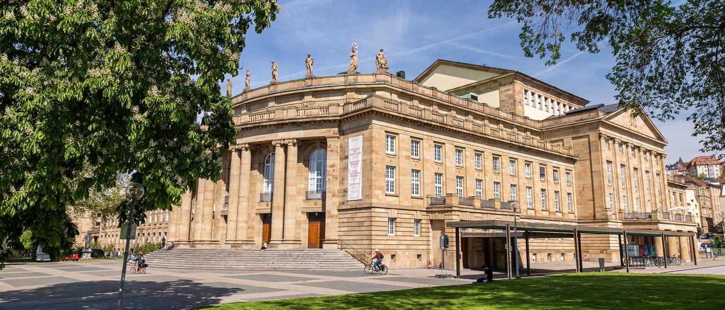 The Stuttgart State Opera in sunny weather, surrounded by green trees and a cyclist in the foreground., &copy; Stuttgart Marketing GmbH, Sarah Schmid