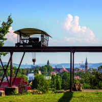 Alte Seilbahn im Travertinpark, im Vordergrund B&auml;ume und Wiese, im Hintergrund Stadtansicht mit Kircht&uuml;rmen und H&uuml;geln., &copy; Stuttgart-Marketing GmbH
