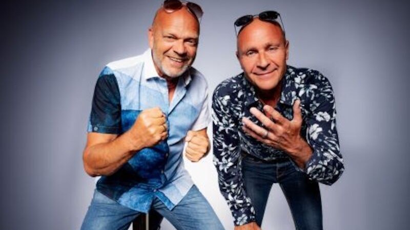 Zwei Männer in lässiger Kleidung posieren fröhlich vor einem neutralen Hintergrund. Beide tragen Sonnenbrillen auf dem Kopf., © Theaterhaus Stuttgart e.V. Zwei Männer in lässiger Kleidung posieren fröhlich vor einem neutralen Hintergrund. Beide tragen Sonnenbrillen auf dem Kopf., © Theaterhaus Stuttgart e.V.